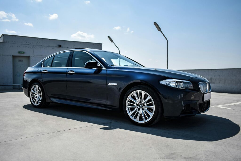 Μαύρη BMW σειράς 5 σε ανοιχτό χώρο στάθμευσης
